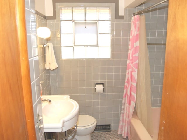 full bathroom with tile walls, toilet, shower / tub combo, a sink, and tile patterned floors