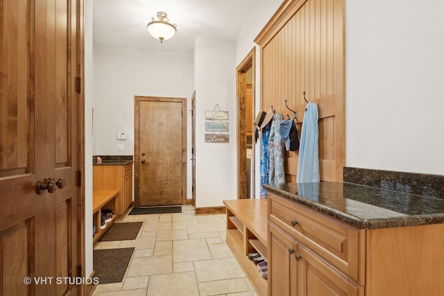 mudroom featuring baseboards and stone tile floors