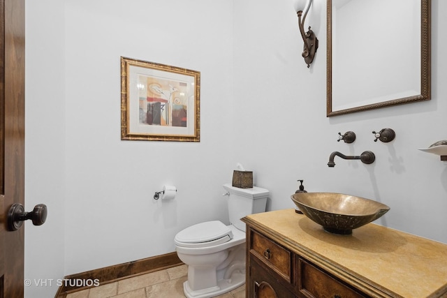 half bath with vanity, toilet, and baseboards