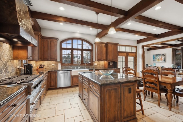 kitchen with a center island with sink, a breakfast bar area, stainless steel appliances, premium range hood, and backsplash