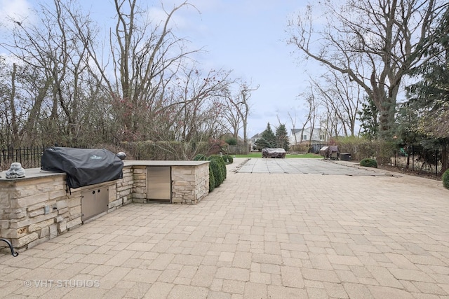 view of patio / terrace with exterior kitchen, grilling area, and fence