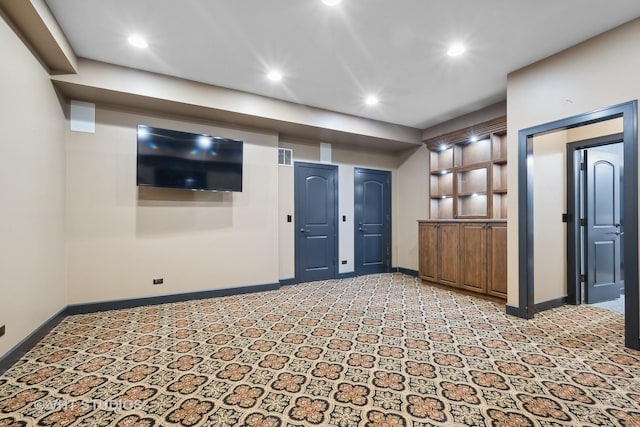 empty room with recessed lighting, light colored carpet, visible vents, and baseboards