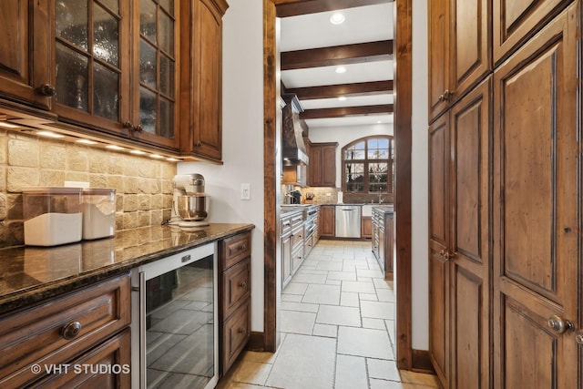 kitchen with beam ceiling, decorative backsplash, stainless steel dishwasher, dark stone countertops, and beverage cooler