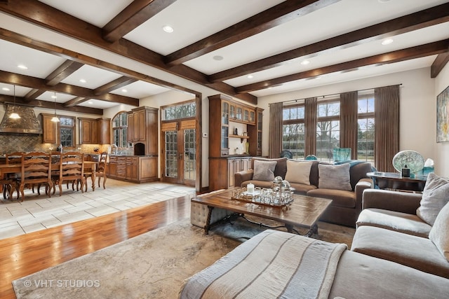 living room with recessed lighting, beamed ceiling, and light wood finished floors