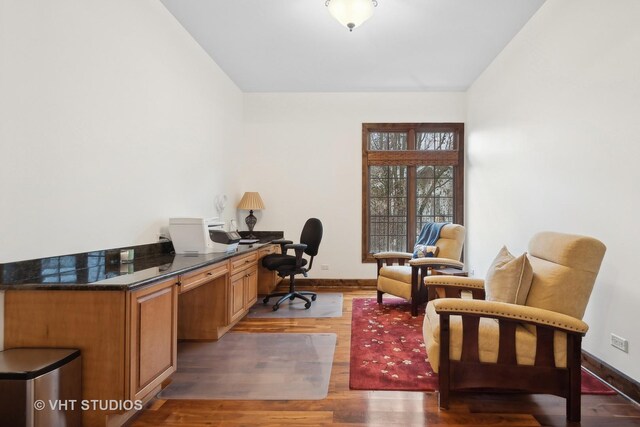 home office featuring lofted ceiling, light wood-style flooring, and baseboards