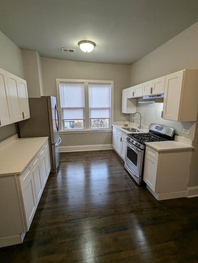 kitchen with visible vents, a sink, stainless steel appliances, light countertops, and white cabinetry