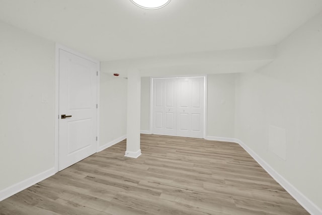 finished basement featuring light wood-style flooring and baseboards