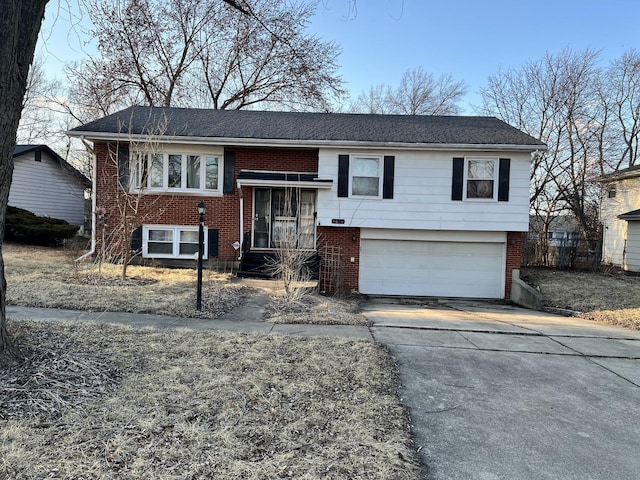 split foyer home featuring an attached garage, concrete driveway, and brick siding