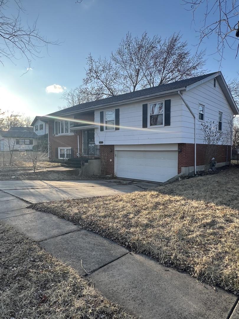 4656 176th Pl, Country Club Hills, IL 60478 - raised ranch featuring a garage, driveway, and brick siding