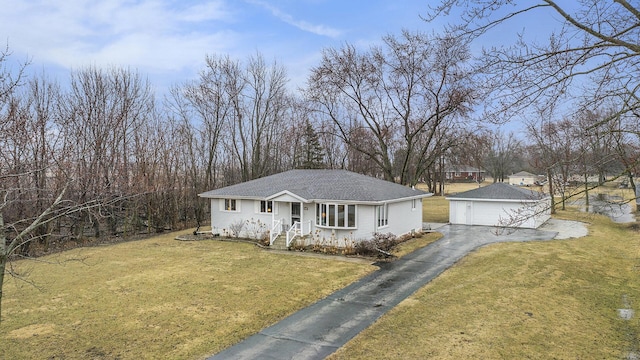 single story home with an outbuilding, a garage, a front yard, and roof with shingles