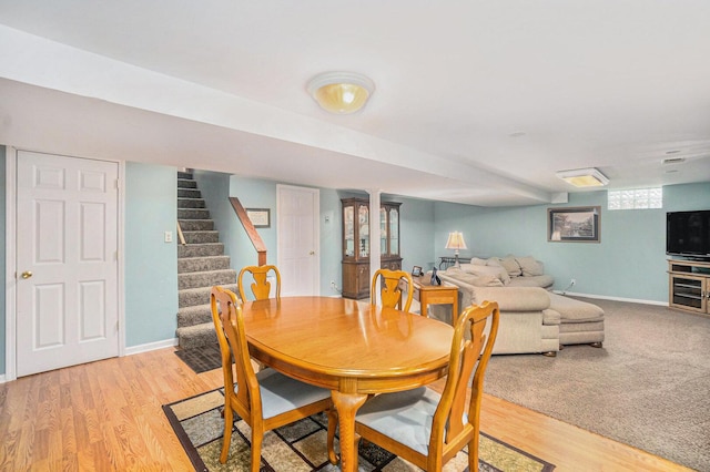 dining area featuring stairway, light wood-style flooring, and baseboards