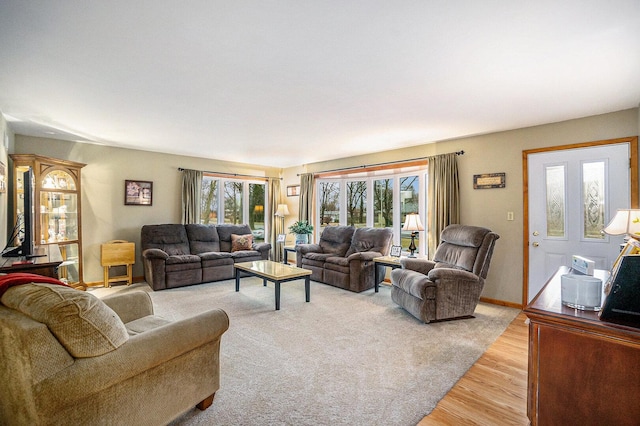 living area featuring a healthy amount of sunlight, light wood-style flooring, and baseboards