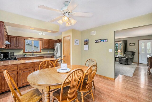 dining space with ceiling fan, visible vents, baseboards, and light wood-style flooring