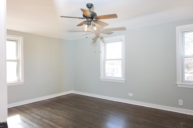 spare room featuring a ceiling fan, dark wood-type flooring, and baseboards