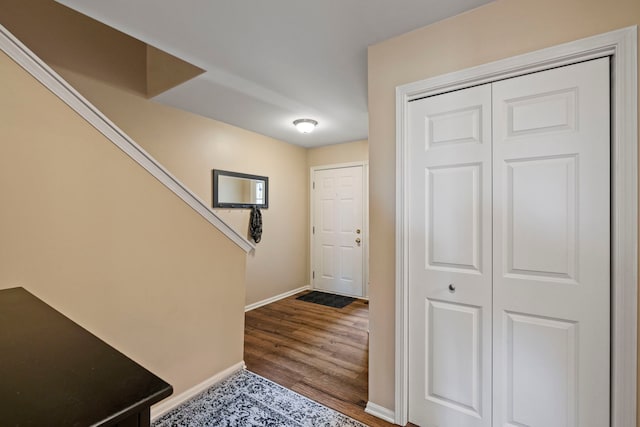 interior space featuring baseboards, wood finished floors, and stairs