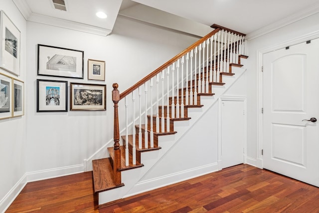 stairway featuring wood finished floors, baseboards, visible vents, recessed lighting, and crown molding