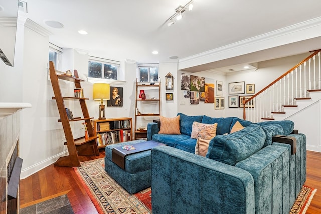 living room featuring wood finished floors, baseboards, recessed lighting, ornamental molding, and stairs