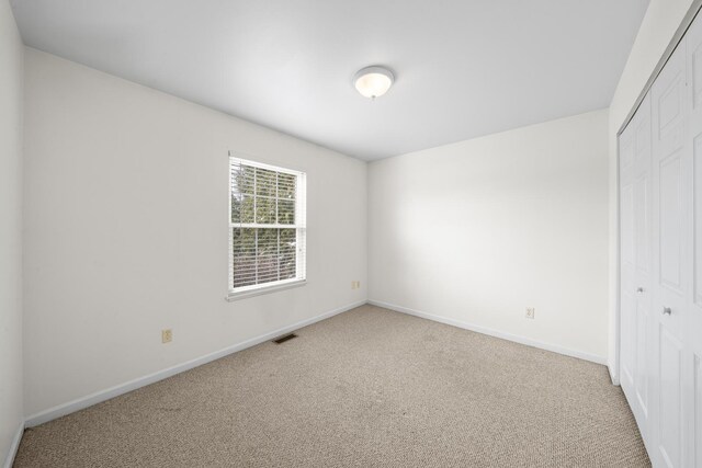 606 Effie Dr, Earlville, IL 60518 - unfurnished bedroom featuring a closet, light carpet, and baseboards