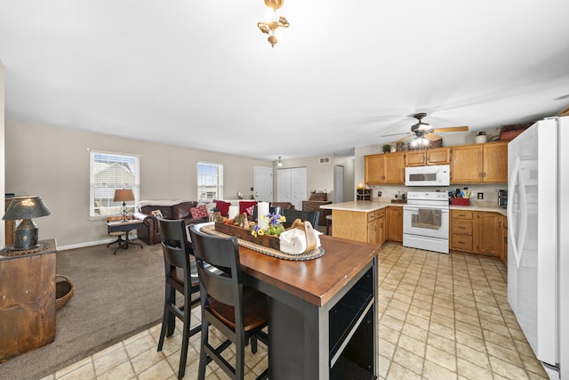 606 Effie Dr, Earlville, IL 60518 - kitchen with white appliances, open floor plan, light countertops, ceiling fan, and light colored carpet