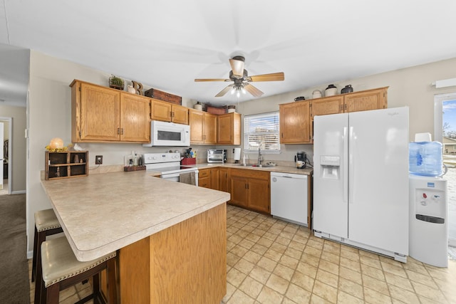 606 Effie Dr, Earlville, IL 60518 - kitchen with white appliances, a sink, a peninsula, light countertops, and a ceiling fan