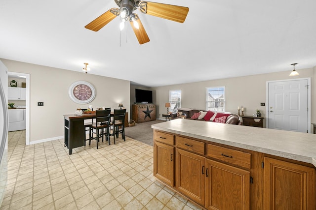 606 Effie Dr, Earlville, IL 60518 - kitchen with light countertops, brown cabinets, washer / dryer, and a ceiling fan