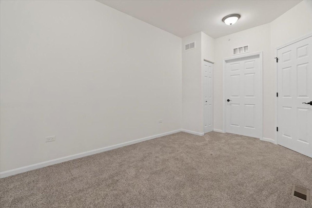 unfurnished room featuring baseboards, visible vents, and light colored carpet