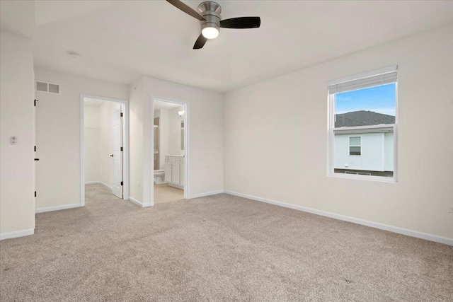 carpeted empty room featuring a ceiling fan, visible vents, and baseboards