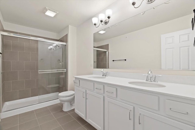 bathroom featuring toilet, a shower stall, a sink, and tile patterned floors