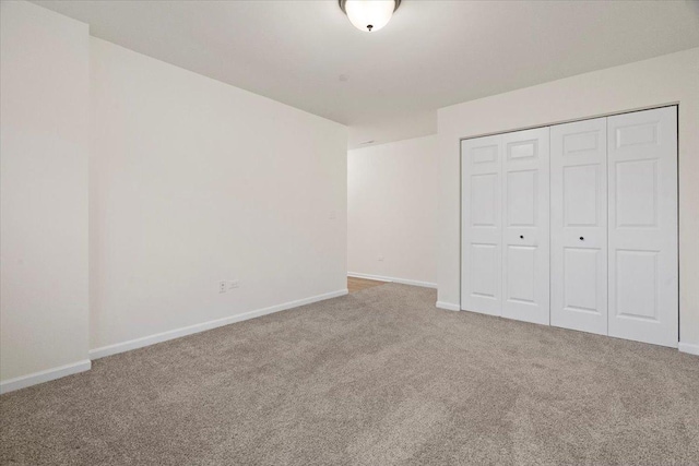 unfurnished bedroom featuring a closet, carpet, and baseboards