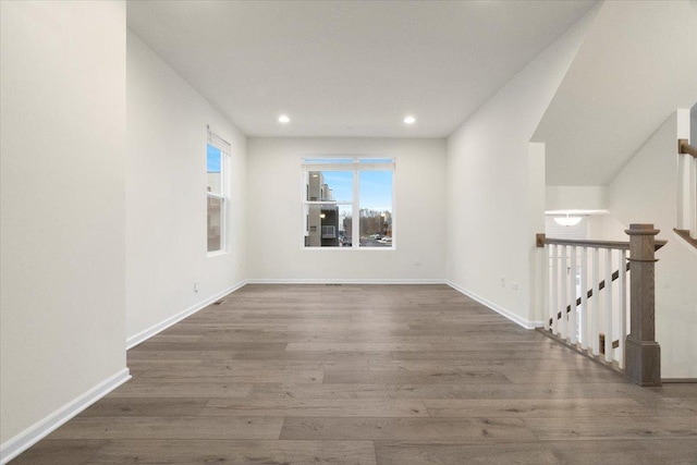 spare room with recessed lighting, baseboards, and wood finished floors