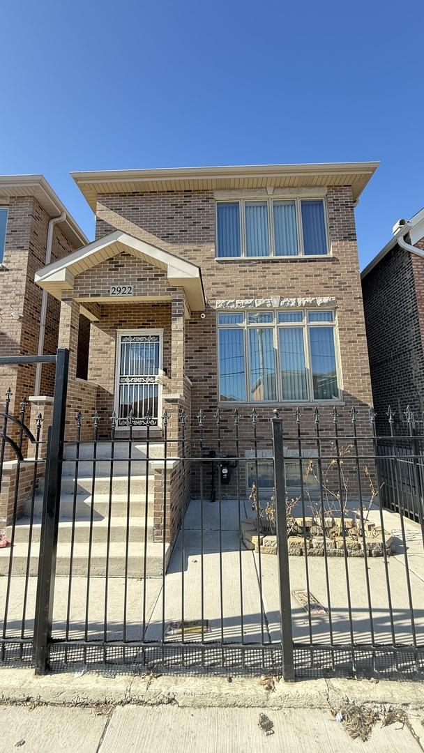 view of front of home with a fenced front yard and brick siding