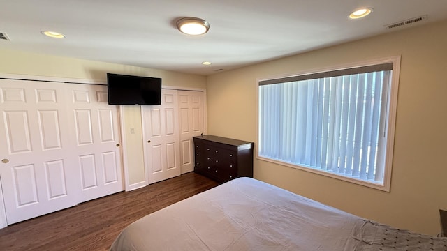 bedroom with recessed lighting, visible vents, multiple closets, and dark wood-style floors