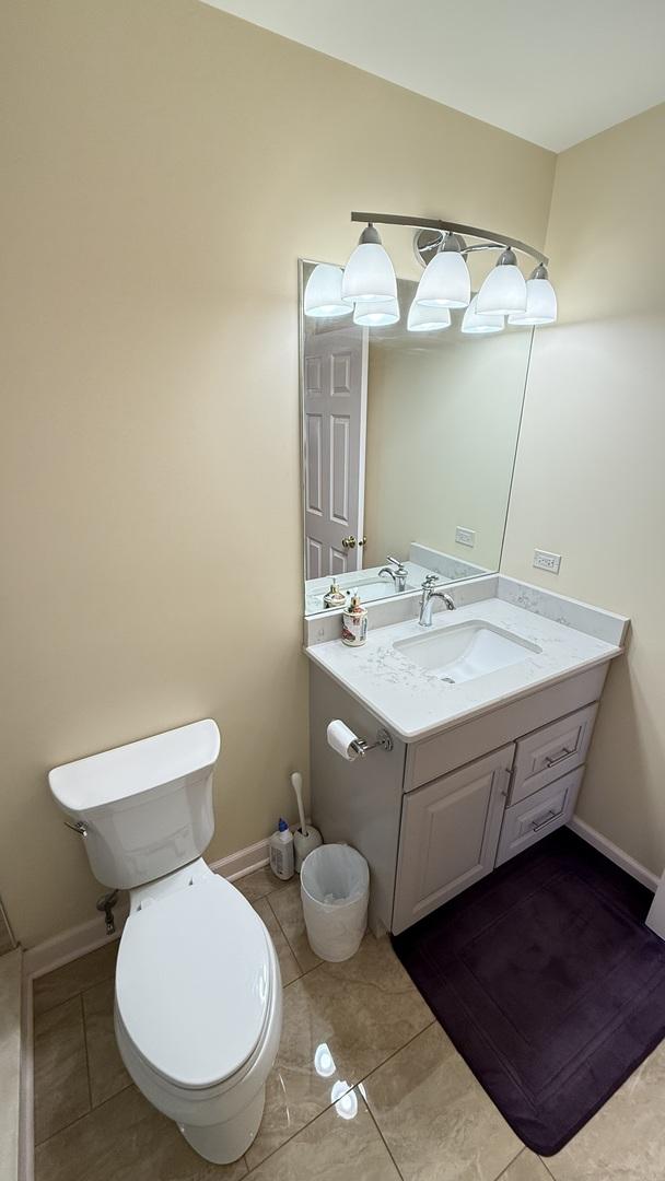 bathroom with tile patterned flooring, toilet, vanity, and baseboards