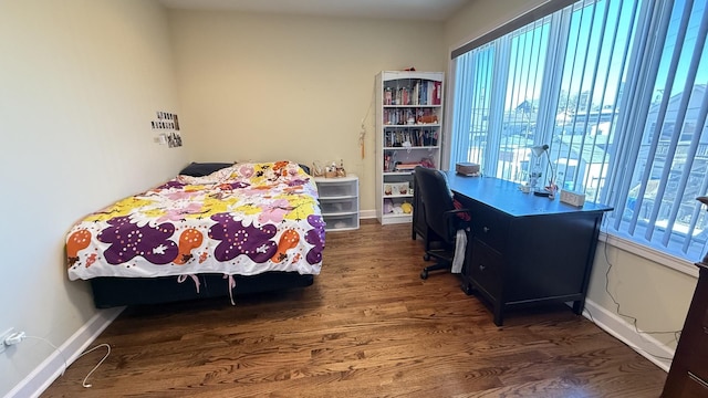 bedroom with baseboards and wood finished floors