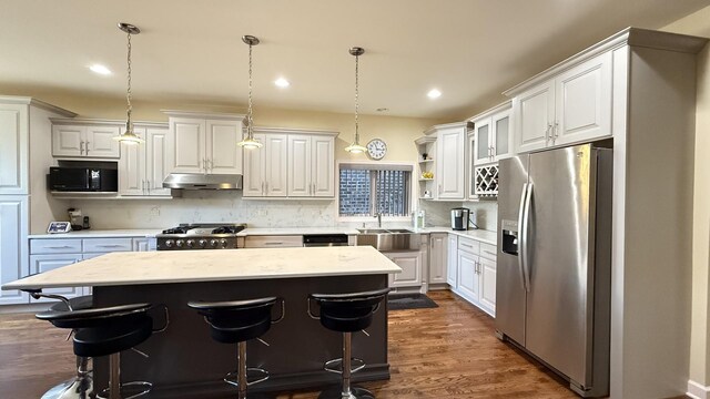 kitchen featuring a kitchen island, stainless steel fridge with ice dispenser, under cabinet range hood, black microwave, and range