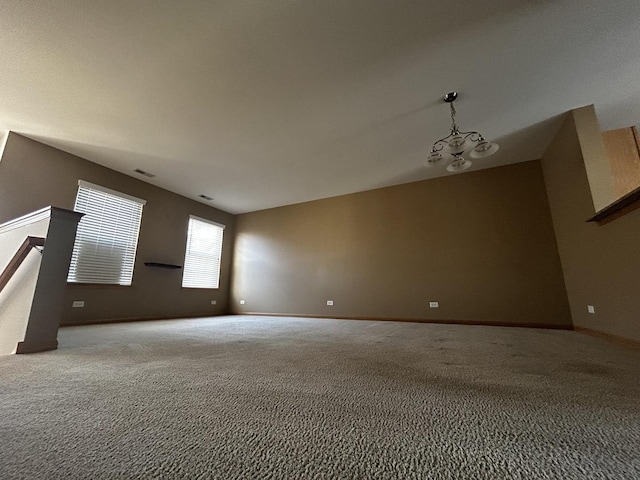 carpeted spare room with visible vents and baseboards