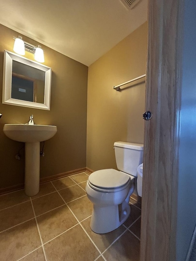 bathroom featuring tile patterned floors, baseboards, toilet, and lofted ceiling