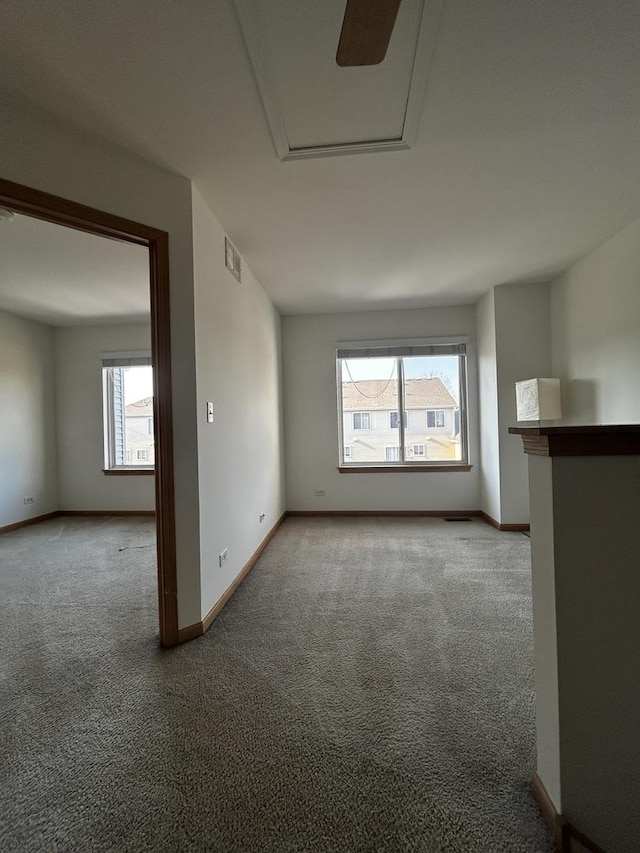 empty room featuring visible vents, baseboards, and carpet flooring