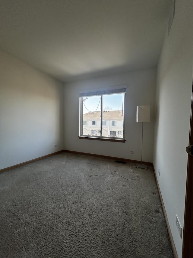 unfurnished room with visible vents, carpet, and baseboards