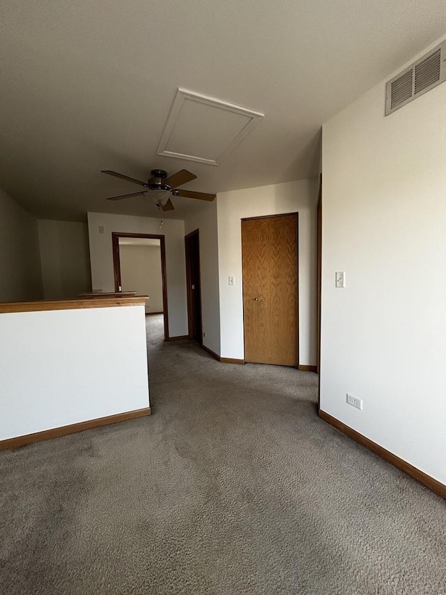 carpeted empty room featuring visible vents, ceiling fan, and baseboards