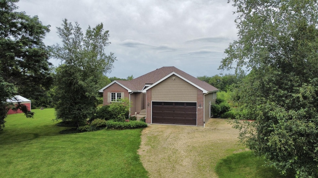 single story home featuring brick siding, driveway, and a front yard