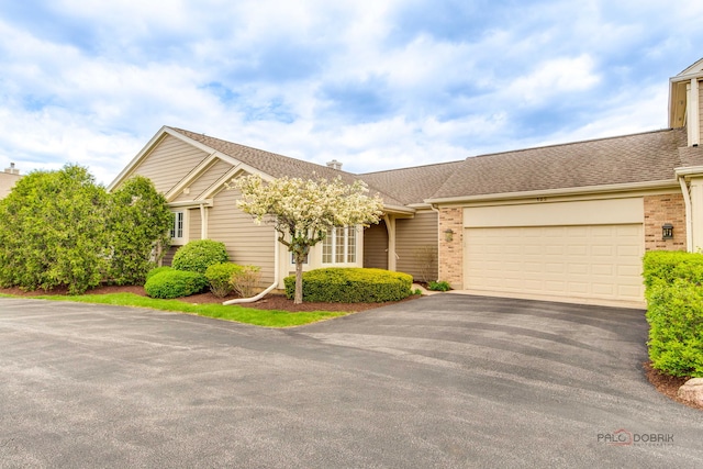 122 Kilchurn Ln, Inverness, IL 60067 - view of front facade with asphalt driveway, brick siding, an attached garage, roof with shingles, and a chimney
