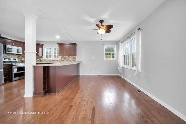 kitchen with visible vents, decorative backsplash, appliances with stainless steel finishes, wood finished floors, and ornate columns