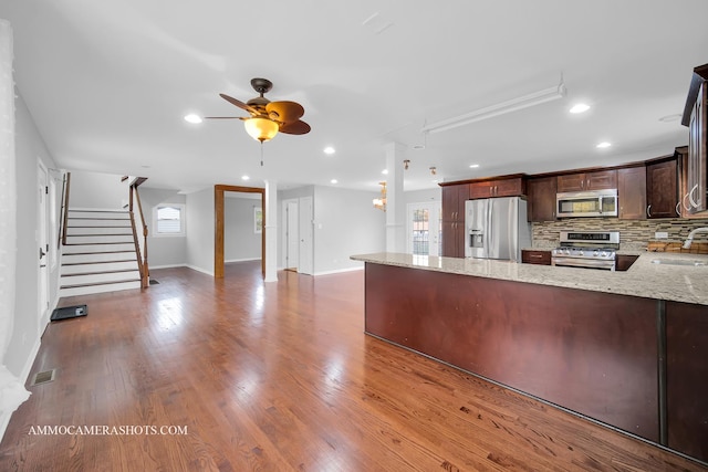 kitchen with a wealth of natural light, visible vents, decorative backsplash, appliances with stainless steel finishes, and a peninsula