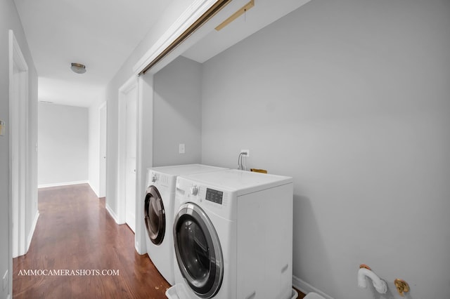 washroom with laundry area, washing machine and dryer, baseboards, and dark wood-type flooring