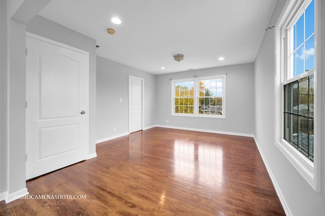 unfurnished room featuring recessed lighting, wood finished floors, and baseboards