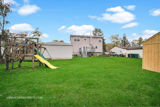 rear view of property featuring an outbuilding, a playground, and a lawn