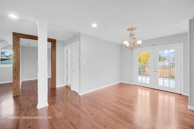 interior space featuring ornate columns, baseboards, wood finished floors, and recessed lighting