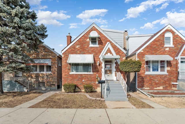 view of front of home with brick siding and a chimney