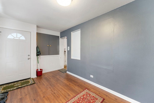 foyer entrance with wood finished floors and baseboards